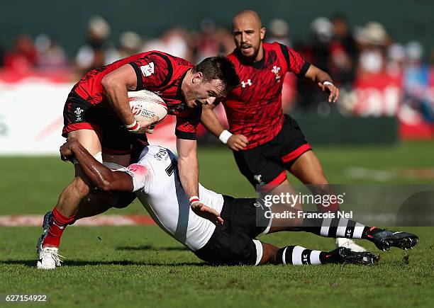 Lloyd Evans of Wales is tackled by Osea Kolinisau of Fiji during day two of the Emirates Dubai Rugby Sevens - HSBC World Sevens Series on December 2,...