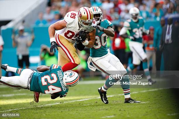 Vance McDonald of the San Francisco 49ers runs after making a reception during the game against the Miami Dolphins at Hard Rock Stadium on November...