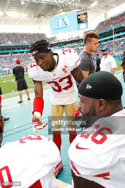 Rashard Robinson of the San Francisco 49ers talks with Tramaine Brock on the sideline during the game against the Miami Dolphins at Hard Rock Stadium...