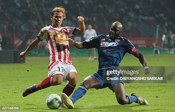 Atletico de Kolkata midfielder Bidyananda Singh vies for the ball with FC Pune City midfielder Mohammed Sissoko during the Indian Super League...