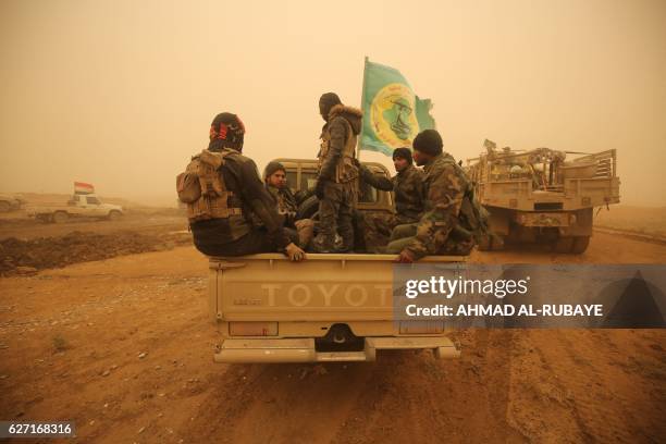 Shiite fighters from the Hashed al-Shaabi paramilitaries drivE through a desert area near the village of Al-Boutha al-Sharqiyah, west of Mosul, on...