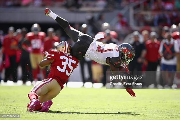 Peyton Barber of the Tampa Bay Buccaneers is tackled by Eric Reid of the San Francisco 49ers at Levi's Stadium on October 23, 2016 in Santa Clara,...