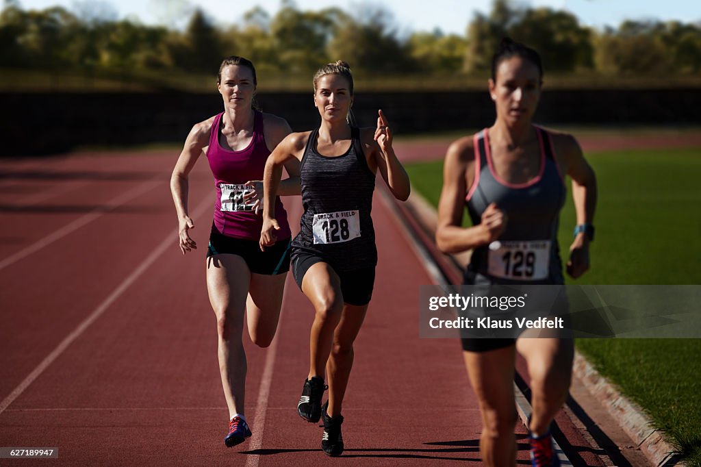 Female runners racing at stadium