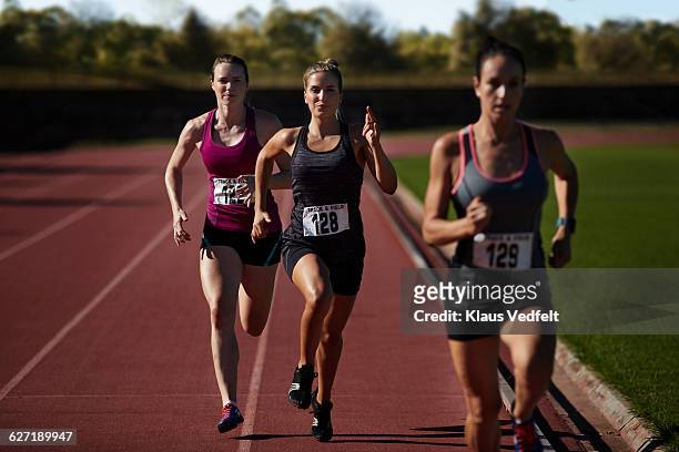 female runners racing at stadium - short track imagens e fotografias de stock