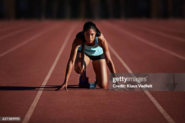 portrait of female runner getting ready - línea de salida fotografías e imágenes de stock