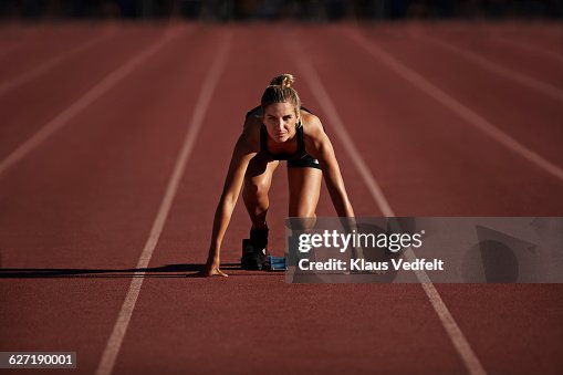 Portrait of female runner in start block Portrait of female runner in start block