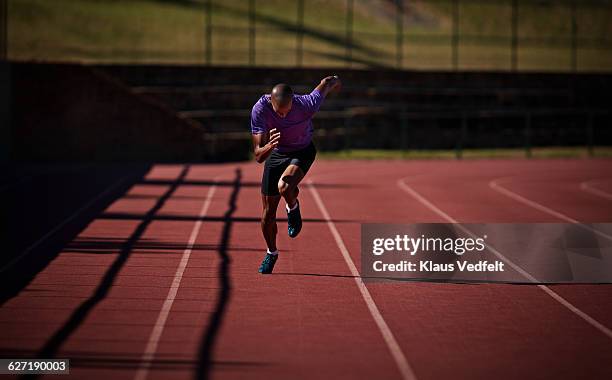 male runner sprinting at stadium - train tracks stockfoto's en -beelden