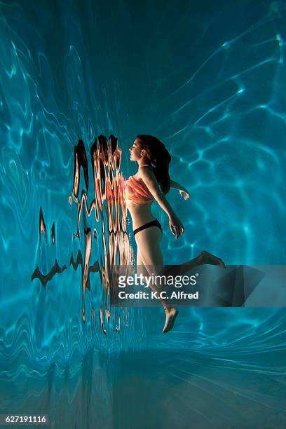 portrait of a female model underwater in a swimming pool in san diego, california - underwater female models stock pictures, royalty-free photos & images