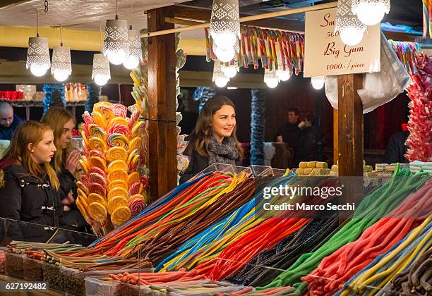 Tourists buy sweets at a Christmas market stall on December 2, 2016 in Budapest, Hungary. The traditional Christmas market and lights will stay until...