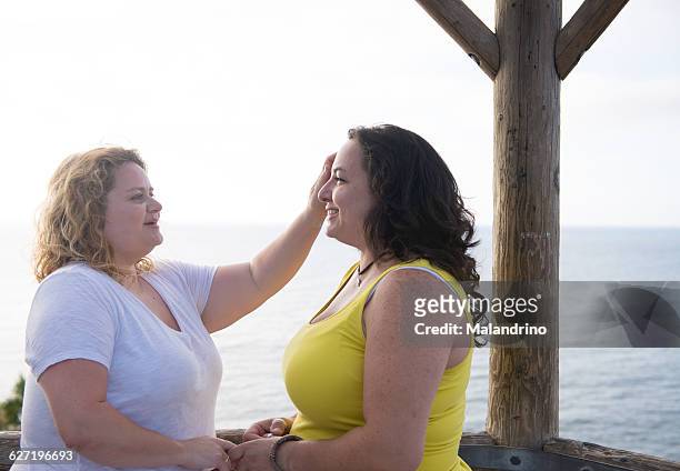 woman touching her wife - redondo beach california - fotografias e filmes do acervo