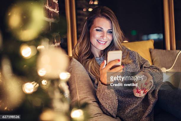 trinken kakao und denken über weihnachten - winter woman phone stock-fotos und bilder