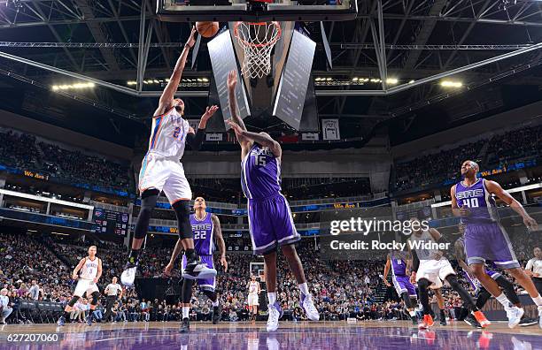 Andre Roberson of the Oklahoma City Thunder shoots a layup against DeMarcus Cousins of the Sacramento Kings on November 23, 2016 at Golden 1 Center...