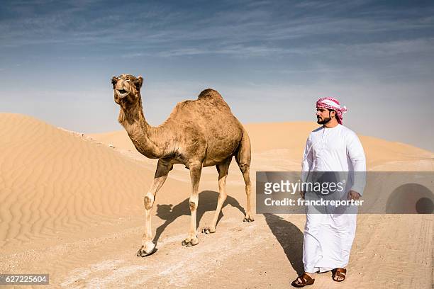 arabic sheik on the desert walking with the camel - people from oman stockfoto's en -beelden
