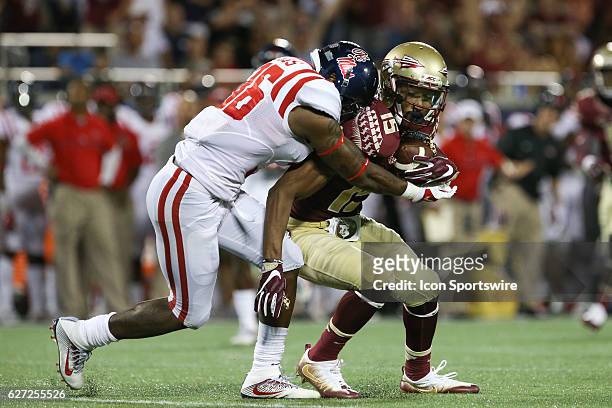 Florida State Seminoles wide receiver Travis Rudolph is wrapped up by Mississippi Rebels defensive back Zedrick Woods after catching a pass for a 1st...