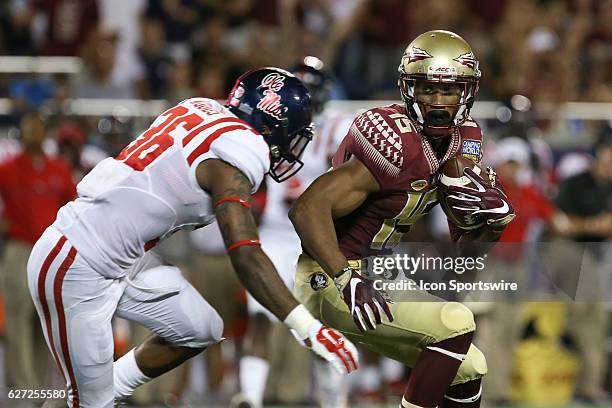Florida State Seminoles wide receiver Travis Rudolph tries to avoid Mississippi Rebels defensive back Zedrick Woods after catching a pass in the 4th...