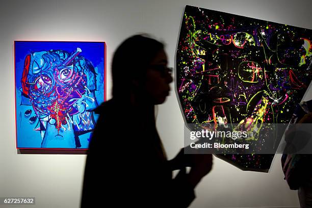 Visitor walks past various art installations on display during Art Basel Miami Beach in Miami, Florida, U.S., on Friday, Dec. 2, 2016. Politics is...