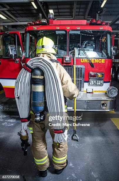full shot of fireman wearing full protection equipment and truck - canadian culture stock pictures, royalty-free photos & images