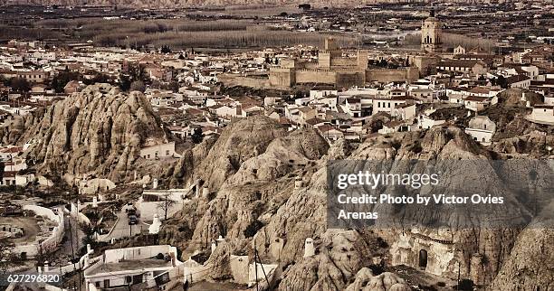 view of guadix with its cave dwellings and its castle and cathedral in the background in granada province, andalusia, spain - granada province imagens e fotografias de stock