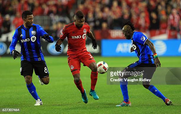 Armando Cooper of Toronto FC battles for the ball with Patrice Bernier and Dominic Oduro of Montreal Impact during the first half of the MLS Eastern...