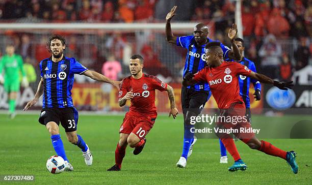 Sebastian Giovinco of Toronto FC battles for the ball with Marco Donadel of Montreal Impact during the first half of the MLS Eastern Conference...