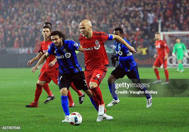 Michael Bradley of Toronto FC battles for the ball with Marco Donadel of Montreal Impact during the first half of the MLS Eastern Conference Final,...