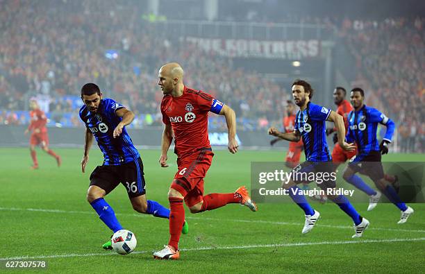 Michael Bradley of Toronto FC battle for the ball with Víctor Cabrera of Montreal Impact during the first half of the MLS Eastern Conference Final,...