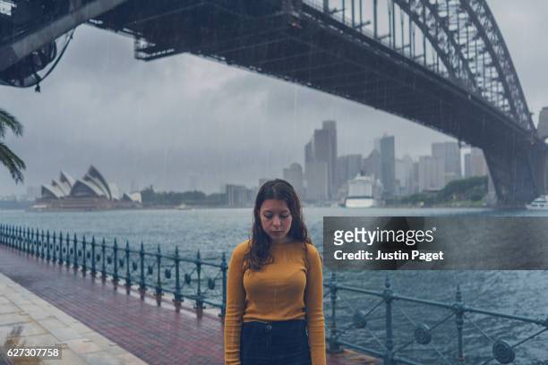wet tourist by sydney harbour bridge - sydney rain stock pictures, royalty-free photos & images