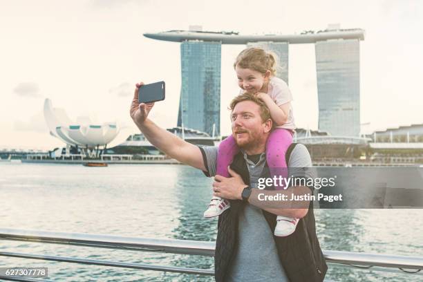 father and daughter taking selfie in singapore - singapore tourist stock pictures, royalty-free photos & images