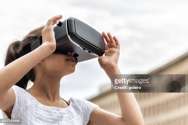 fille avec simulateur de réalité virtuelle en plein air - casques réalité virtuelle photos et images de collection