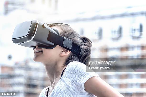 mädchen mit virtual-reality-simulator in der stadt - head mounted display stock-fotos und bilder