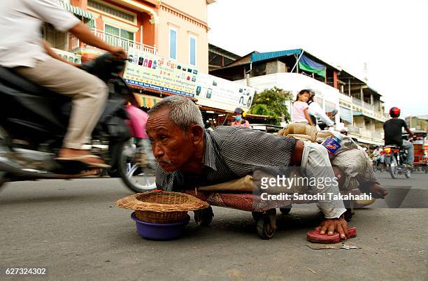 Man has handicap to both legs. He lives by begging on a street.