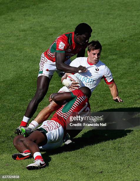 Liam Underwood of Canada is tackled by Willy Ambaka and Nelson Oyoo of Kenya during the Emirates Dubai Rugby Sevens - HSBC World Sevens Series Trophy...