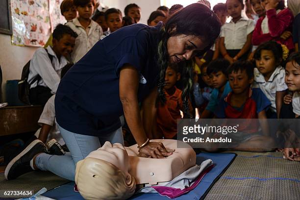 Chan Sovanna from Safety When It Matters Cambodia demonstrates how to perform CPR on a mannequin during a water safety and drowning prevention class...