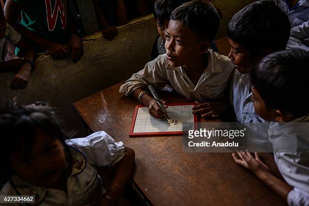 Children write down what they use water for in their daily lives during a class on water safety and drowning prevention in Prey Veng Province,...