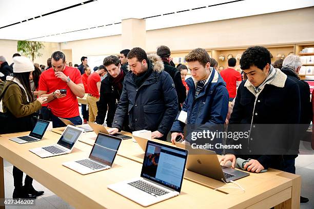 Customers check the new MacBook Pro laptop computer inside the new Apple store Saint-Germain during the first opening day on December 03, 2016 in...