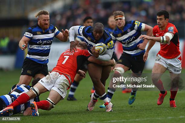 Beno Obano of Bath powers his way through the challenge of Schalk Burger of Saracens during the Aviva Premiership match between Bath Rugby and...