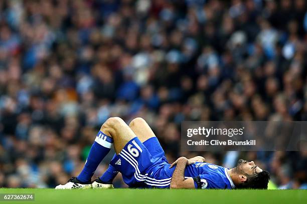 Diego Costa of Chelsea lies injured during the Premier League match between Manchester City and Chelsea at Etihad Stadium on December 3, 2016 in...