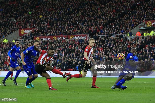 Sunderland's English striker Jermain Defoe shoots at goal, but the ball hits the back of Leicester City's English-born Jamaican defender Wes Morgan...