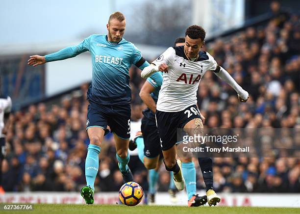 Dele Alli of Tottenham Hotspur and Mike van der Hoorn of Swansea City compete for the ball during the Premier League match between Tottenham Hotspur...