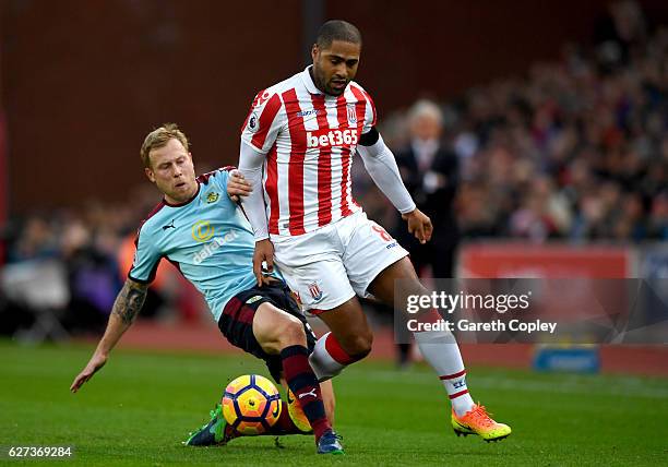 Glen Johnson of Stoke City and Scott Arfield of Burnley compete for the ball during the Premier League match between Stoke City and Burnley at Bet365...