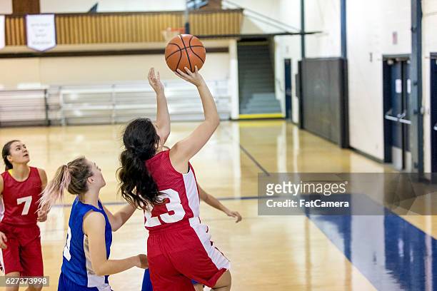 diverses high-school-frauen-basketballteam, das ein spiel spielt - womens basketball stock-fotos und bilder