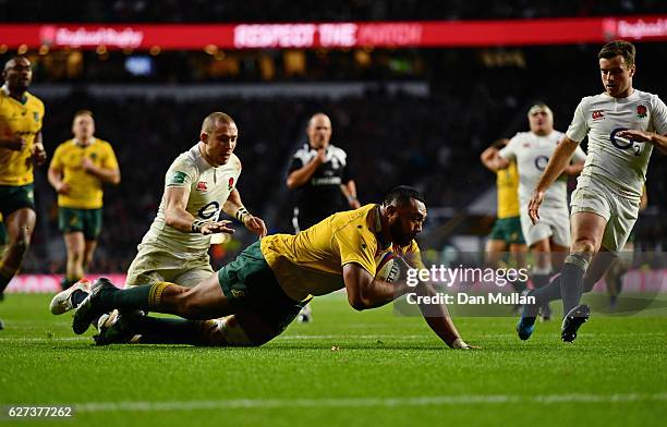 Sekope Kepu of Australia scores his sides third try as Mike Brown of England attempts to catch him during the Old Mutual Wealth Series match between...