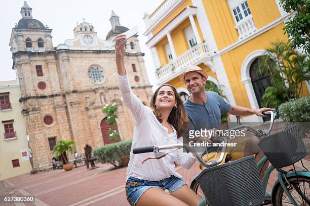 paar macht ein selfie während sightseeing auf fahrrädern - city tour stock-fotos und bilder