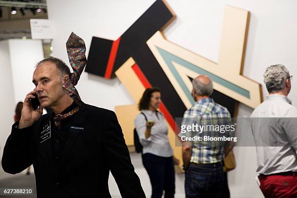Visual artist Alexander Lynx speaks on a mobile phone while viewing art installations during Art Basel Miami Beach in Miami, Florida, U.S., on...