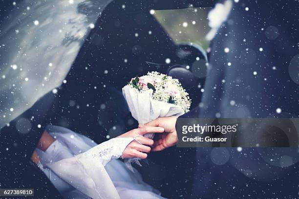 Winter wedding couple groom meets bride from car, bouquet flowers