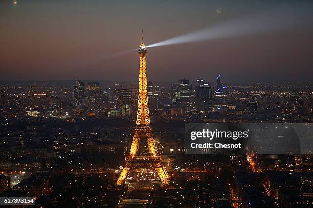 The Eiffel tower and the business district of La Defense are seen by night on December 03, 2016 in Paris, France. The city of Paris remains the top...