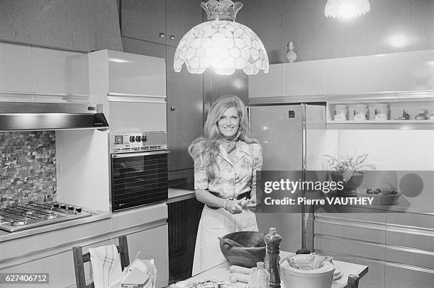 Egyptian-born singer Dalida cooks a meal in the kitchen of her home in Montmartre, Paris.