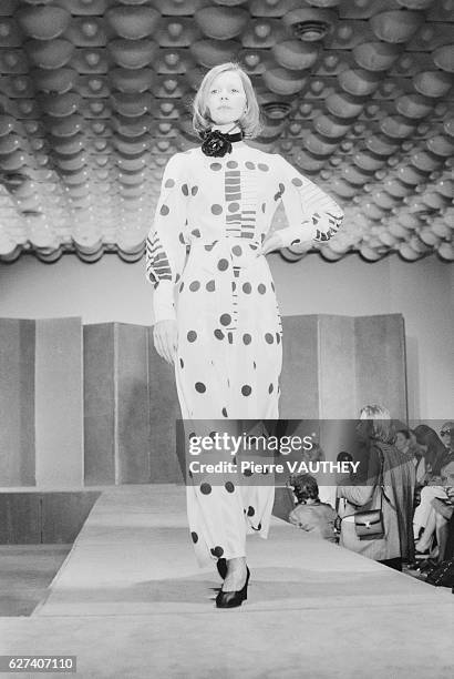 Fashion model wears a long-sleeved, polka dot haute couture dress by French fashion designer Louis Feraud. She modeled the dress during his 1973-1974...