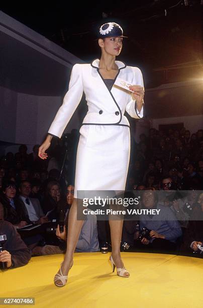 Fashion model wears a white haute couture blazer and skirt by French fashion designer Pierre Cardin. She modeled the suit during his spring-summer...