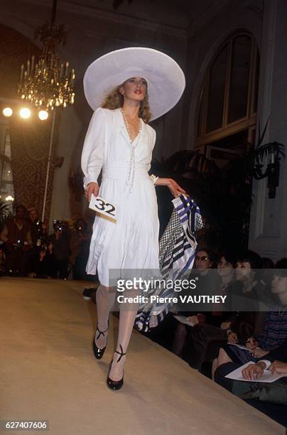 Fashion model wears a white haute couture dress and wide brimmed hat by French fashion designer Marc Bohan for French fashion house Christian Dior....